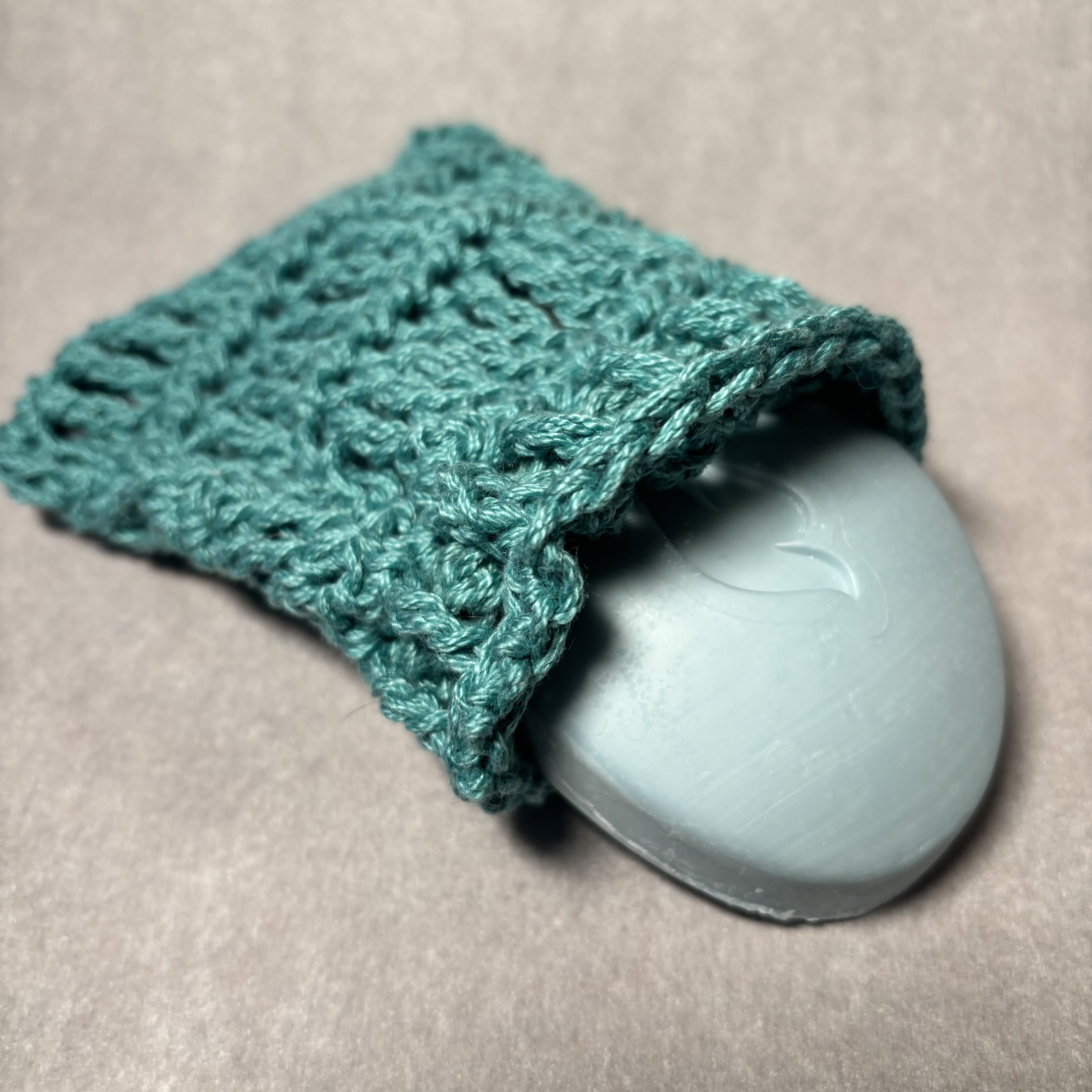 A crochet soapsaver with a bar of soap in it.
